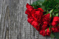 Красные розы на деревянном столе